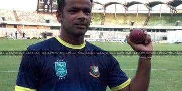 Cricketer holding a cricket ball.