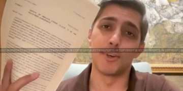 Man holding and showing a paper