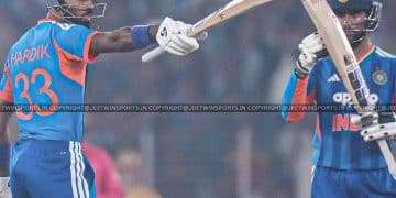 Cricket batsman gesturing with his bat during a live match