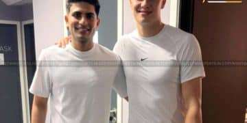 Two men with arms around each other’s shoulders posing for a photo